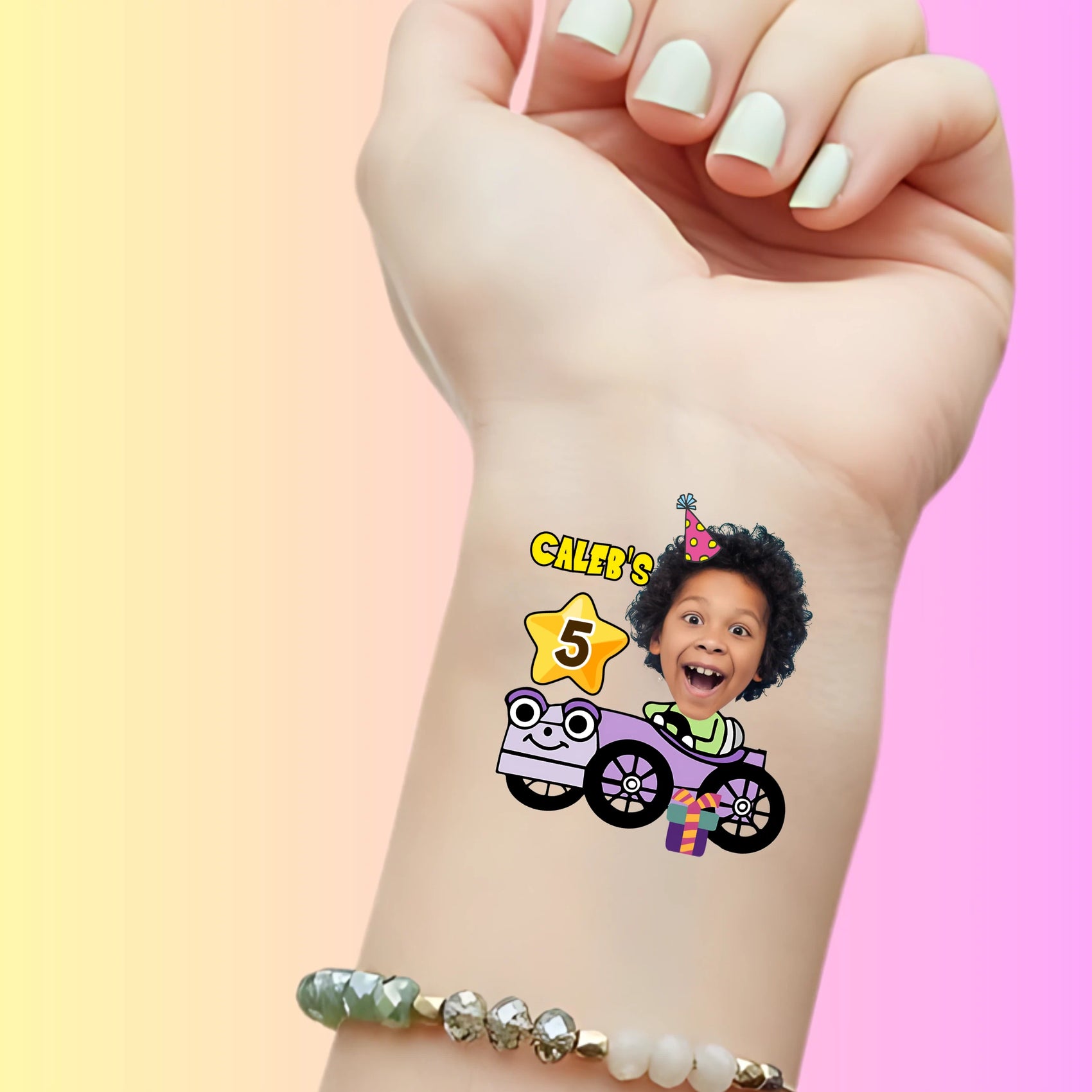 Custom temporary tattoo on wrist with excited child's face in purple car, party hat, star with number 5, and gift for birthday party favor