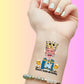custom temporary tattoo on wrist featuring a king with a crown and headphones, two dancing beer mugs, and text David's 60th Birthday, personalized party favor for birthday