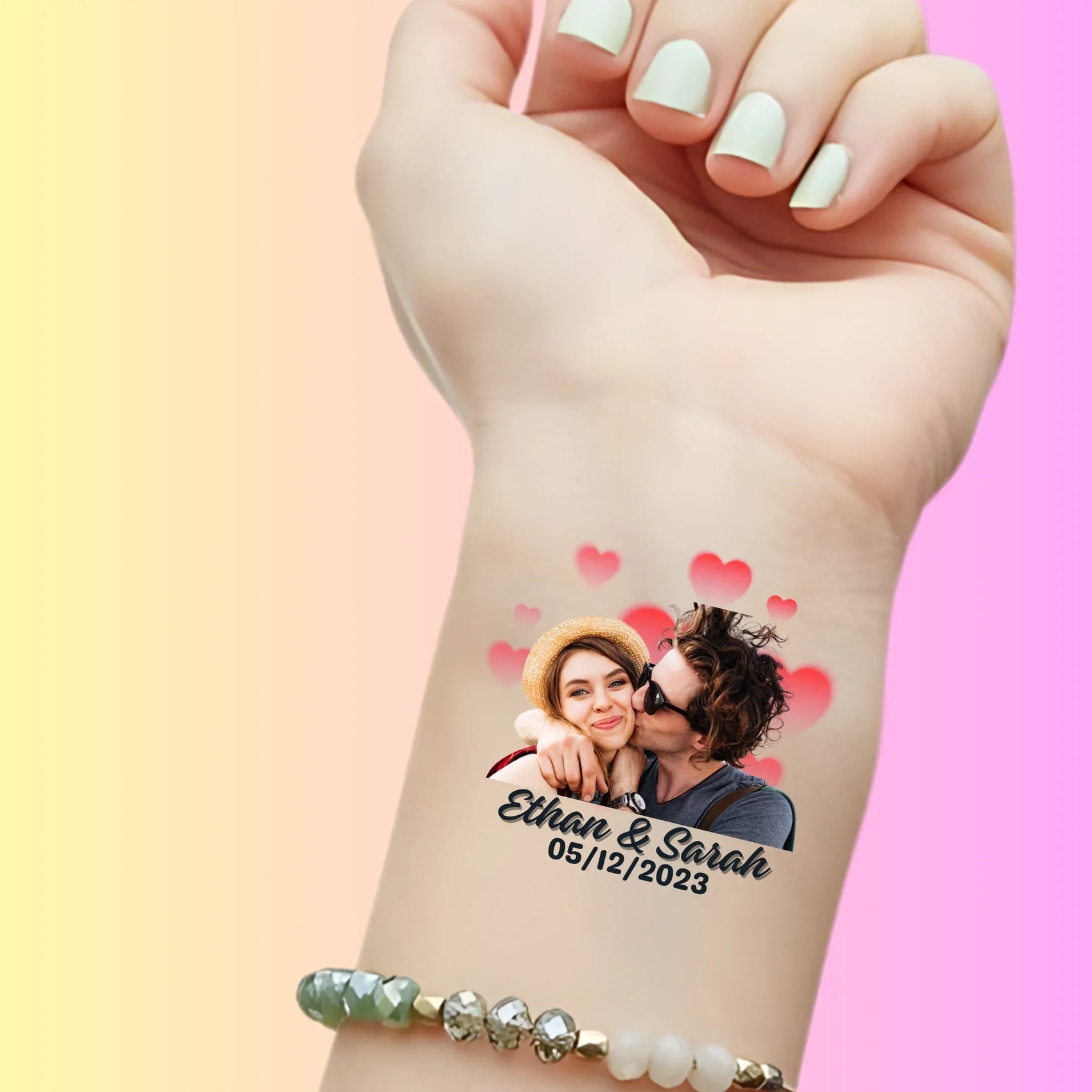 Custom temporary tattoo on wrist featuring couple photo, hearts, and text Ethan & Sarah 05/12/2023 for personalized wedding favor
